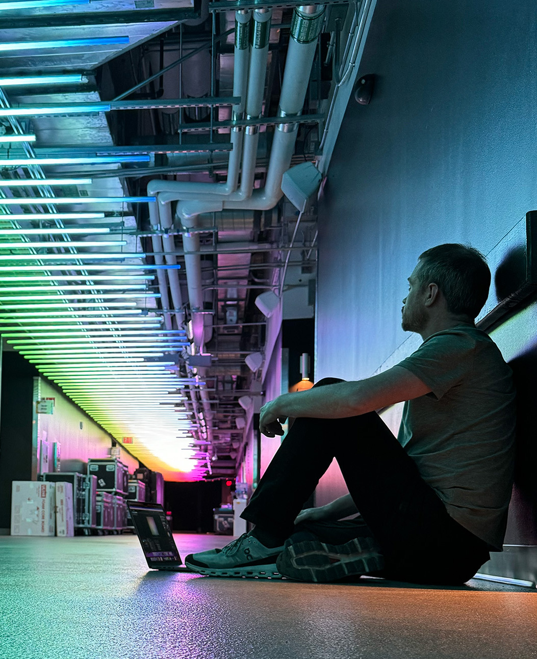 Geoffrey Hicks seated inside a colorful architectural light installation.