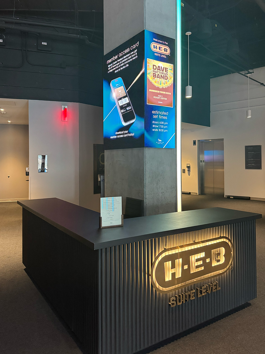 Fine-pitch LED video wall wrapping around a column behind a premium level welcome desk.